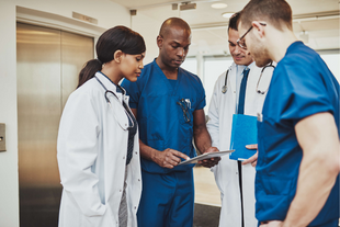 Group of clinicians having a discussion in a hospital corridor