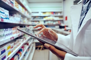Clinician in a pharmacy holds an iPad