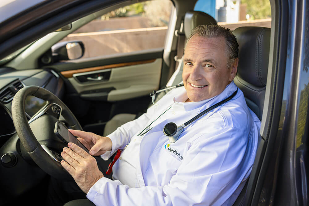 A clinician smiles after he reads positive Signify Health reviews.