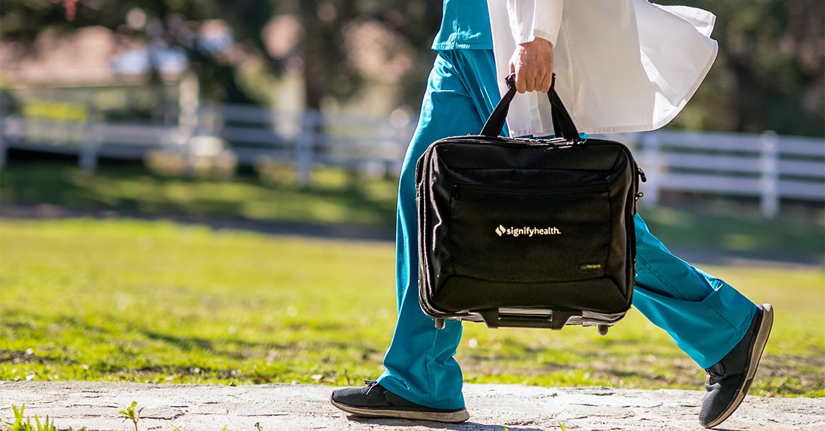 Clinician walking on side walk to member's home